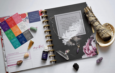 planner surrounded by crystals and sage